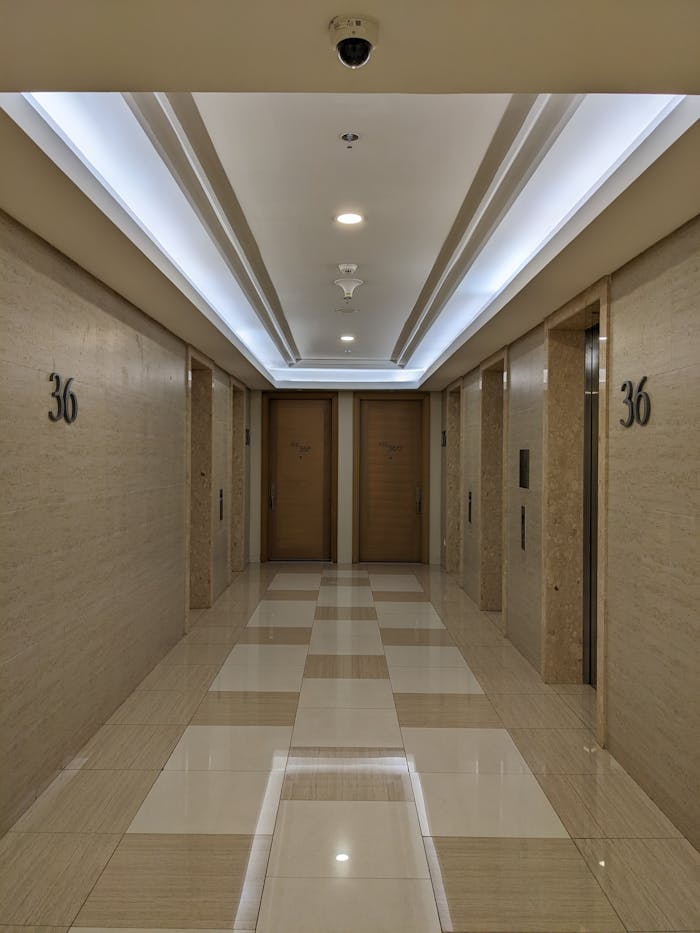 Spacious and well-lit hotel corridor on the 36th floor with elevator access.
